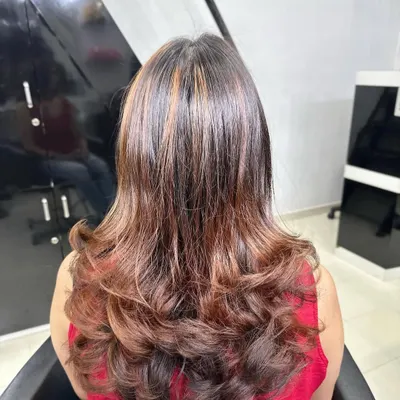 A beautiful example of copper brown hair highlights. I styled it with layered curls at the end to add volume and show how the light catches the different warm tones in the hair.