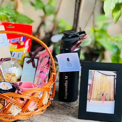 A beautiful farewell gift basket for a valued colleague. This hamper includes a personalized water bottle, a photo frame, and a collection of their favorite snacks and wellness items.