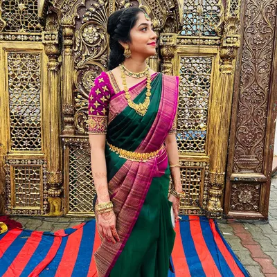 My absolute beauty, Nagambika, ready for her brother's muhurtham. For the groom's sister, we went with a natural yet radiant look, featuring glowing skin and a bright lip that perfectly matches her stunning green and purple silk saree.