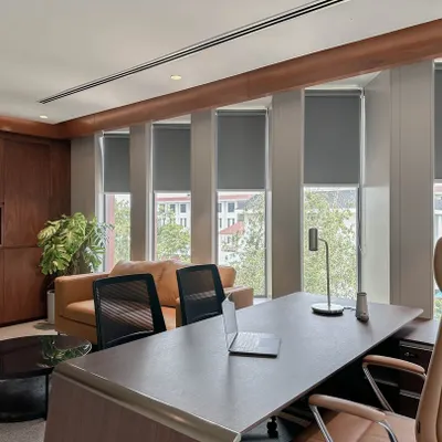 A wide view of a senior executive's office, showing the layout that includes a work desk, an informal meeting lounge, and ample natural light. The design balances privacy with a connection to the rest of the office.