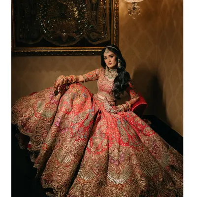 A portrait that is all about the grandeur of the bridal lehenga. The intricate embroidery and the sheer volume of the skirt create a stunning image of bridal opulence at The Leela Palace Udaipur.