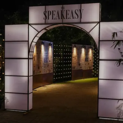 The entrance to our speakeasy event, complete with a custom-built arch and walls collaged with vintage newspaper prints announcing the end of Prohibition. This set the stage for the mystery and excitement inside.