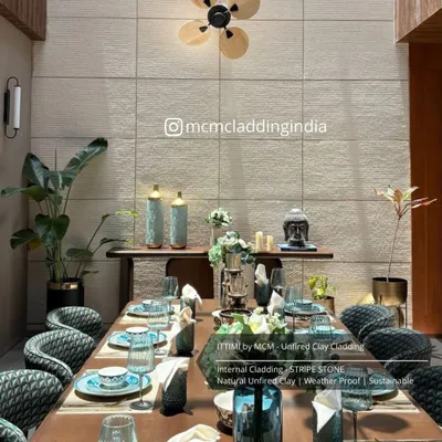 A full dining room setting featuring our Ittimi flexible clay cladding. The 'Stripe Stone' texture adds a subtle, sophisticated backdrop that is both modern and timeless.