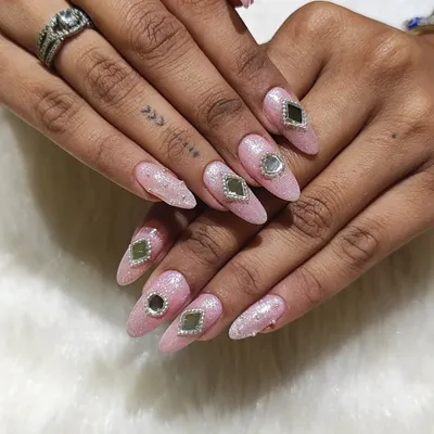 Navratri glam is all about shine. This festive set features almond-shaped extensions with a pink glitter base, adorned with traditional mirror work and silver bead detailing for a perfect garba night look.
