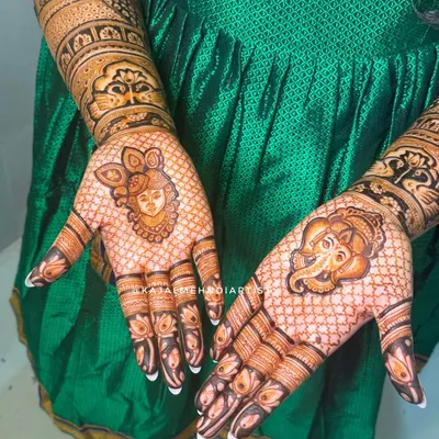 A prayer on the palms. This bridal design features portraits of Shreenathji and Ganpati Bappa to bless the new beginning, surrounded by a delicate net pattern.