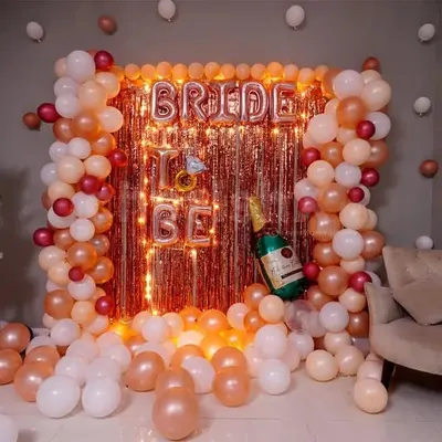 A fun and festive 'Bride to be' decoration, perfect for a bachelorette party or bridal shower at home. This setup features a rose gold fringe curtain, 'BRIDE TO BE' foil balloons, and a surrounding garland of peach, pink, and white balloons. I also scattered balloons on the floor to complete the party look.