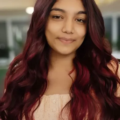 A vibrant red hair transformation that radiates confidence. This look was achieved with careful color application and styling to create soft, beautiful waves.