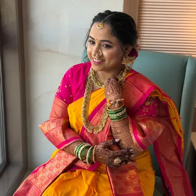 A portrait of a radiant Maharashtrian bride. Her makeup is intentionally gentle and filter-free, designed to feel light on the skin while enhancing her natural grace. The focus is on a subtle glow that looks beautiful in natural light.