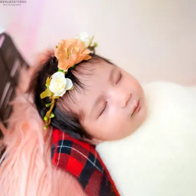 A close-up of a sleeping newborn with a delicate floral headband. I focus on capturing these peaceful, angelic moments that pass by so quickly.