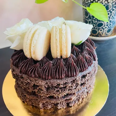 Our ultimate Vegan and Sugar-Free Chocolate Cake. This dessert is also dairy-free and gluten-free, yet remains incredibly moist and tender, topped with macarons and fresh flowers.