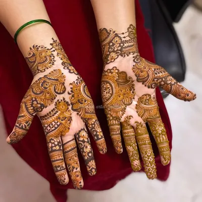 A beautiful Indo-Arabic design that flows diagonally across the hands, combining bold floral and paisley elements with finer, delicate patterns.