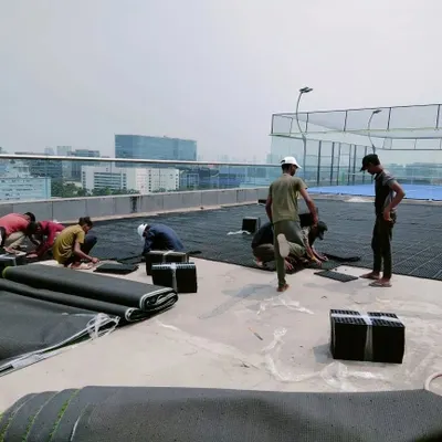 Our team installing modular drain mats on a large rooftop terrace. These mats, made from recycled polypropylene, create a crucial air gap for water to flow freely to drainage outlets.