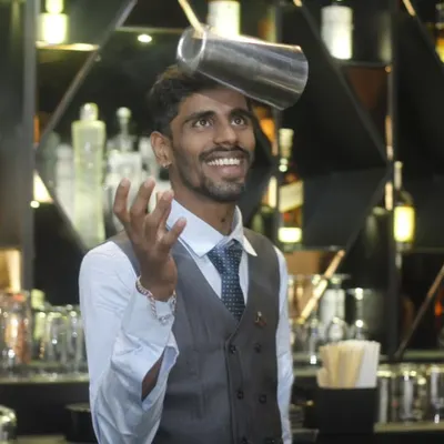 It's not just about the drink, it's about the show. One of our flair bartenders balances a shaker with a smile, adding a dynamic and entertaining element to the guest experience.