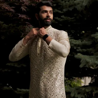 This ivory kurta set is a masterpiece of mirror work. The intricate hand embroidery covers the entire front of the kurta, creating a dazzling effect that is both traditional and incredibly stylish.