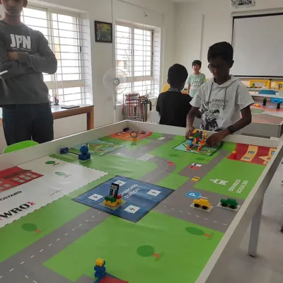 A student tests his creation during our internal robotics competition. The challenge was to build and program an autonomous school bus to navigate a custom-designed mat.