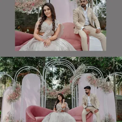 A closer look at the couple enjoying their beautifully styled engagement stage. The combination of the blush pink sofa and delicate floral arrangements on the white arches creates a soft, romantic setting.