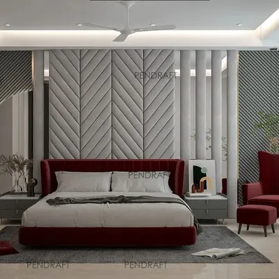 A truly luxurious master bedroom featuring a bold, floor-to-ceiling upholstered headboard in a chevron pattern. The design is elevated with a rich red color palette, mirror paneling, and a cozy reading chair.