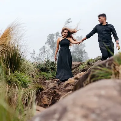 The wind and mist in Munnar's mountains create a beautifully wild and romantic atmosphere. We captured this couple navigating the rocky terrain, her dress catching the wind, for a dramatic and adventurous pre-wedding portrait.