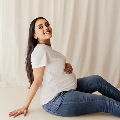 Just you, your bump, and a happy smile. This casual portrait in a simple white tee and jeans is all about celebrating your authentic self during this special time.