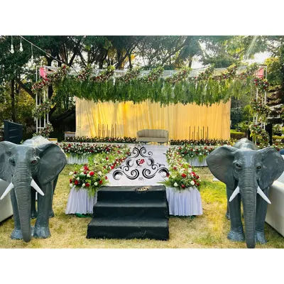 A complete outdoor destination engagement setup, featuring a beautiful stage, a grand aisle, and two life-sized elephant statues for a majestic touch.