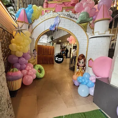 Welcome to the Disney Kingdom! This grand castle entrance arch, adorned with pastel balloons and candy props, sets a magical tone for a princess-themed birthday party.