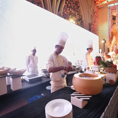 A chef at our live pasta station, tossing pasta in a hollowed-out wheel of Parmesan cheese. This is not just cooking; it's a performance that adds flavour and theatre to your event.