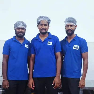 Our dedicated team members in their smart blue HB uniforms and hairnets, representing our commitment to professionalism and hygiene.