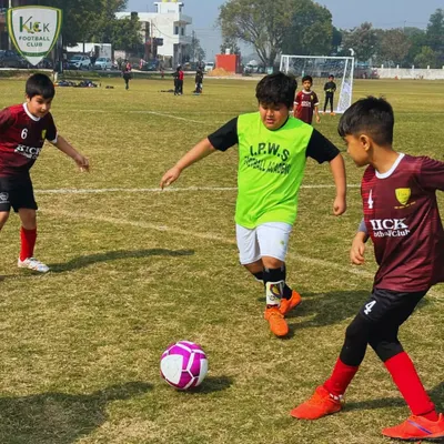 Two players challenge for the ball in a competitive match. This moment captures the intensity and teamwork that defines football.