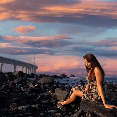 Dreaming in the city of dreams. A beautiful portrait set against the rocky Mumbai shoreline with the Bandra-Worli Sea Link and a pastel sunset sky.