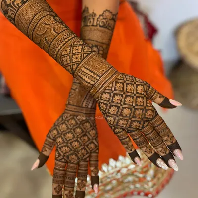 A classic grid or 'jaali' pattern is a timeless choice for the back of the hands. This design is filled with delicate lotus motifs, creating a look that is both intricate and elegant.