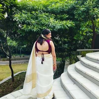 A closer look at the custom-stitched purple blouse. It features a deep back with a delicate tie-up, perfectly complementing the client's white and gold saree.