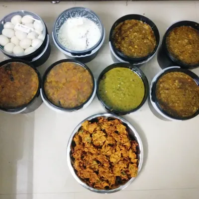 A large order prepared for a corporate company event for 80 people. You can see the different dishes like pakodi, curries, and boiled eggs packed and ready.