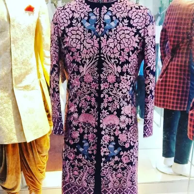 This black velvet sherwani is a prime example of our luxury design work. The heavy floral embroidery in contrasting colors creates a piece that is both artistic and regal, designed for the groom who wants a truly memorable outfit.
