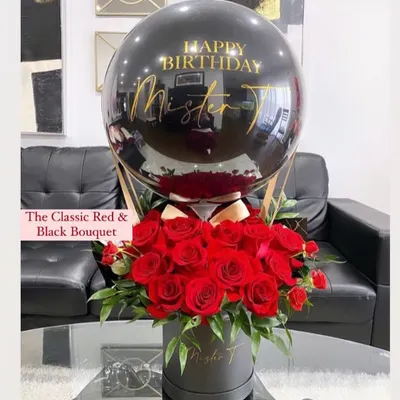 Our classic red and black hot air balloon hamper is pure elegance. It features a personalized message on a sleek black balloon, floating above a box of fresh, deep red roses, making it a perfect gift for a loved one.