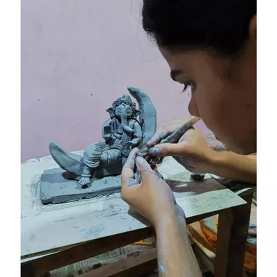 The final touches are the most meditative part of the process. Here, I'm using a small tool to refine the folds of the clothing on a custom Ganesha idol. This level of detail is only possible with careful, patient hand-sculpting.