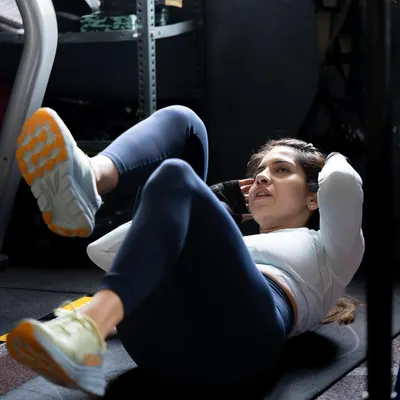 A client performs bicycle crunches, a great exercise for targeting the entire core. We emphasize that a strong core is non-negotiable for posture, injury prevention, and lifting heavier.