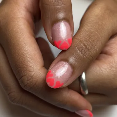 These tips might steal hearts. A fun twist on the French manicure with neon pink heart-shaped tips, perfect for a birthday or just for fun.