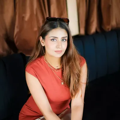 A relaxed and stylish portrait taken in a lounge. The warm, ambient lighting and comfortable seating create a chic lifestyle image, perfect for an influencer's feed.