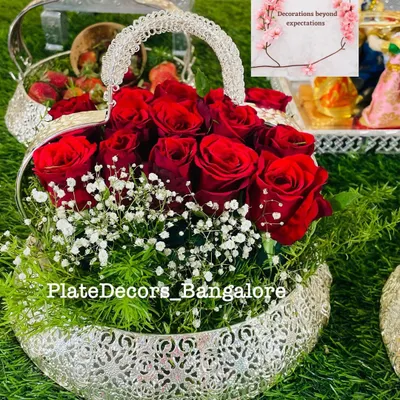A heart-shaped silver basket filled with fresh red roses and baby's breath. This floral arrangement can be a beautiful addition to any gift display or used as a standalone gift.