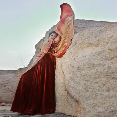 We used the wind to our advantage here, capturing the movement of the golden saree against the static, rugged texture of the rock. It creates a feeling of drama and elegance.