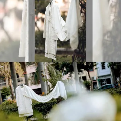 An artistic shot of the groom's white sherwani, hanging in a garden, a symbol of the day's beginning.