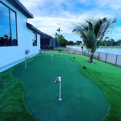 This backyard putting green was designed to fit the long space next to the house, overlooking the water. It features multiple holes for varied putting practice.