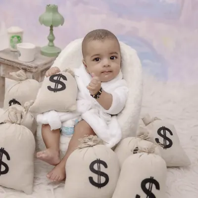 Meet the new boss in town. This creative "Boss Baby" themed shoot is a fun and hilarious way to capture your little one's big personality, complete with a robe and bags of 'money'.
