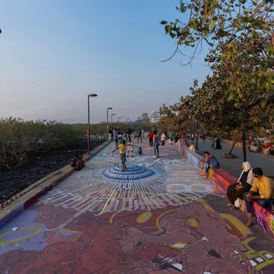 A wide view of the transformed Carter Road promenade, with the central calligraffiti piece drawing people in. The project became a public art landmark.