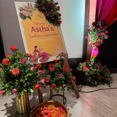 A stunning entrance for a Sindhara celebration, bursting with the vibrant energy of pink and orange roses. The custom welcome easel and lush floral arrangements create a festive and totally Insta-worthy first impression.