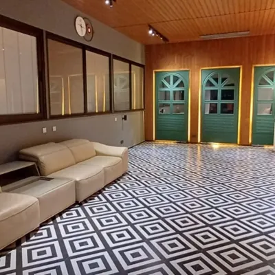 This floor makes a statement. The bold, black-and-white geometric pattern provides a high-contrast, modern foundation for this multi-purpose room, proving that the floor can be the main design feature.