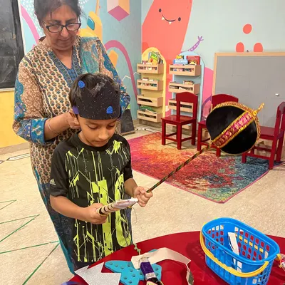 Our Ramleela preps are in full swing! Here I am helping one of our little actors with his crown. We make most of our props and costumes right here, which makes the whole experience more special for the kids.