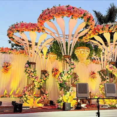 A closer look at the illuminated floral structures I build for my stage designs. These custom pieces are crowned with lush pink and orange flowers and create a warm, inviting glow for evening receptions.