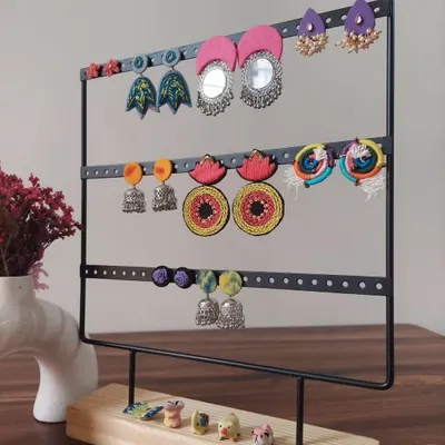 A display of the variety of earrings I create. You can see everything from large mirror work chandbalis and colorful jhumkis to hand-painted studs, all handmade by me.