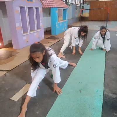 Flexibility is not optional in Taekwondo; it's essential. Here, our students work on their side splits and forward stretches to improve their range of motion for higher, faster kicks.